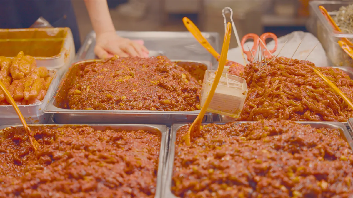 Trays of Korean jeotgal seasoned in red gochujang at a market