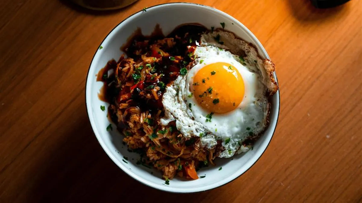 Gochujang kimchi fried rice topped with a fried egg and roasted seaweed